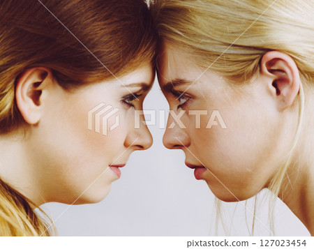 Two girls looking serious at each other. Two girls looking serious at each other. 127023454