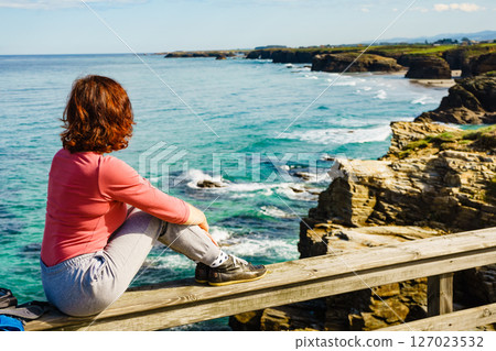 Woman visiting Cathedral Beach in Spain. 127023532