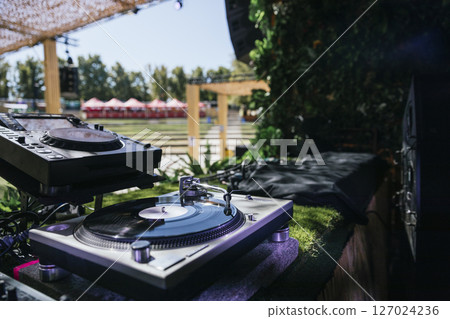 Outdoor DJ Booth with Turntable and Professional Audio Equipment at Music Festival 127024236