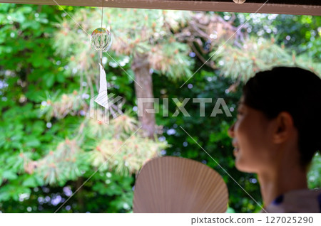 涼爽的午後，一位女士在陽台上欣賞風鈴 127025290