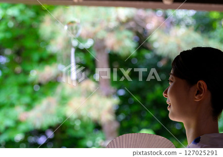 女人看著涼爽的風鈴，表情平靜 127025291