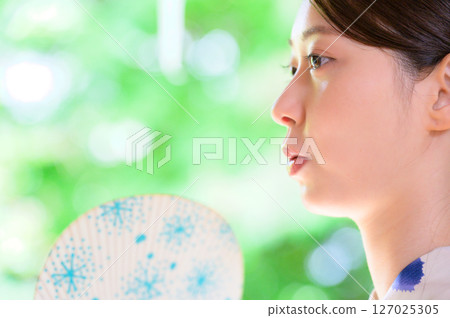 穿著浴衣的女人拿著折扇,看起來很酷的夏日瞬間 穿著浴衣的女人拿著折扇,看起來很酷的夏日瞬間 127025305