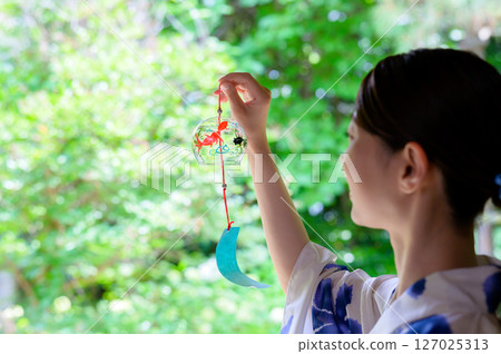 身穿浴衣、手持風鈴的女子,享受涼爽夏日時光 身穿浴衣、手持風鈴的女子,享受涼爽夏日時光 127025313
