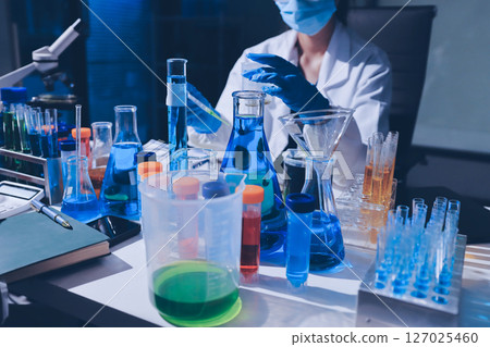 Scientist pipetting medical samples into microplate in laboratory 127025460