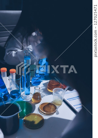 Scientist pipetting medical samples into microplate in laboratory 127025471