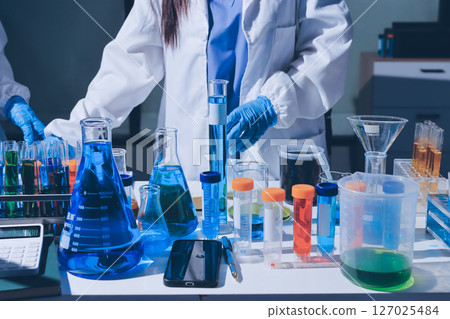 Scientist pipetting medical samples into microplate in laboratory 127025484