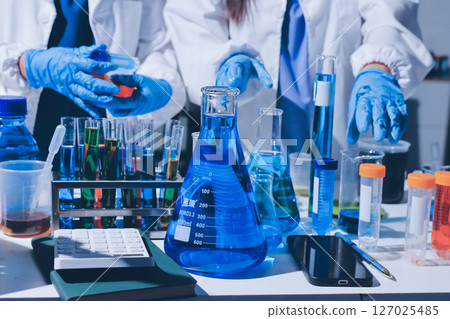 Scientist pipetting medical samples into microplate in laboratory 127025485