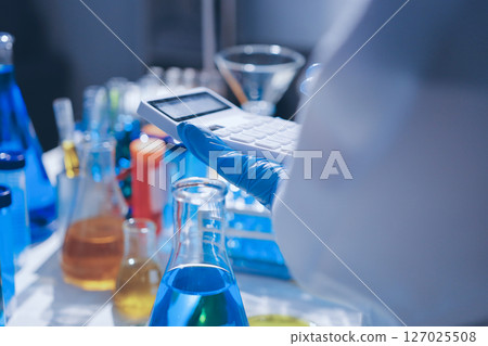 Scientist pipetting medical samples into microplate in laboratory 127025508