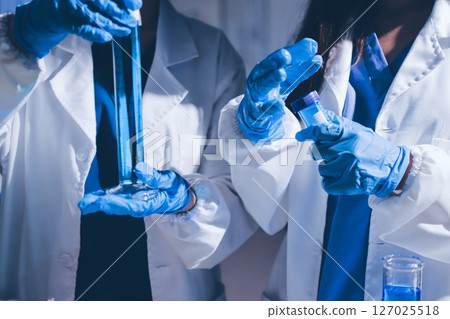 Scientist pipetting medical samples into microplate in laboratory 127025518