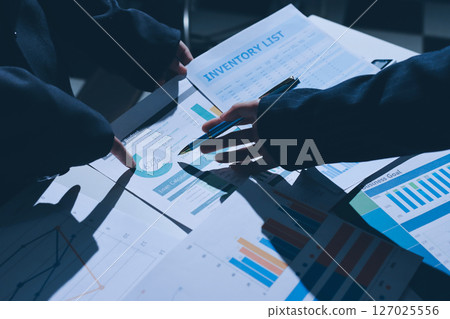 Group of business women working on a financial data expenses document. Group of business women working on a financial data expenses document. 127025556