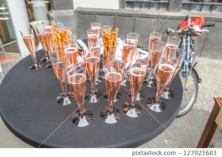 Pouring and tasting of dry sparkling wine champagne festival wedding setup guests 127025683