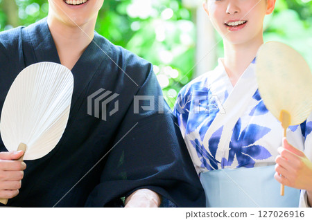 A man and woman in yukata holding fans and hugging each other shows the warmth of summer A man and woman in yukata holding fans and hugging each other shows the warmth of summer 127026916