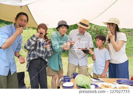 Friends enjoying a meal at a campsite 127027755