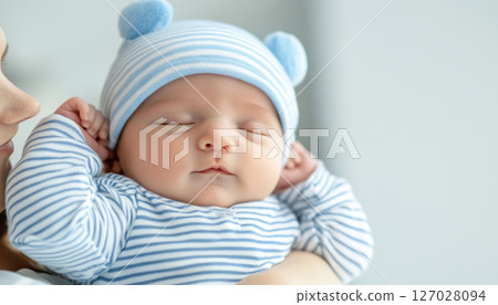 Newborn baby sleeping in mothers arms, both wrapped in blankets 127028094