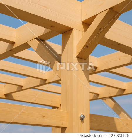 Wooden beam construction detail of country house against blue sky, background 127028126