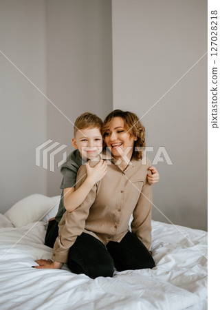 Mother and Son Sharing a Joyful Moment on Bed Mother and Son Sharing a Joyful Moment on Bed 127028218