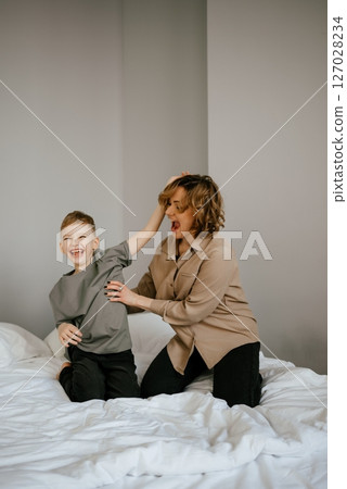 Mother and Son Laughing and Playing on Bed Mother and Son Laughing and Playing on Bed 127028234