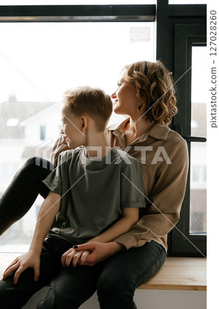 Mother and Son Enjoy Peaceful Moment by Window 127028260