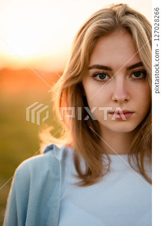 Woman in Field Adjusting Hair at Sunset Woman in Field Adjusting Hair at Sunset 127028266