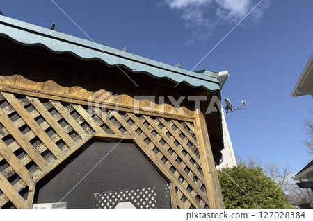 wooden lattice gazebo against blue sky 127028384