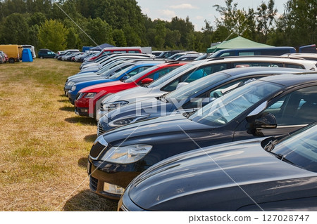 Many Cars Parking on Grass by a Festival Many Cars Parking on Grass by a Festival 127028747