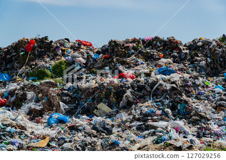 Landfill filled with heaps of garbage, plastic waste, and debris severely impacting the surrounding environment and ecological balance 127029256