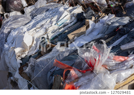 Various types of recyclable materials are stacked together at a waste management facility, showcasing the importance of recycling efforts 127029481