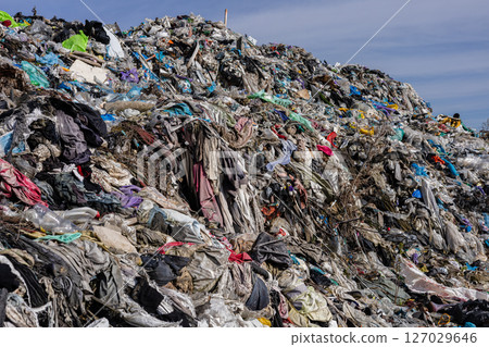 Numerous layers of garbage and discarded materials stack up at a landfill, showcasing the heavy pollution and environmental impact 127029646