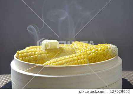 Cooking corn butter in a steamer with rising steam 127029993