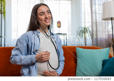 Happy pregnant young woman using stethoscope listening to baby heartbeat unborn child vital signs Happy pregnant young woman using stethoscope listening to baby heartbeat unborn child vital signs 127030085