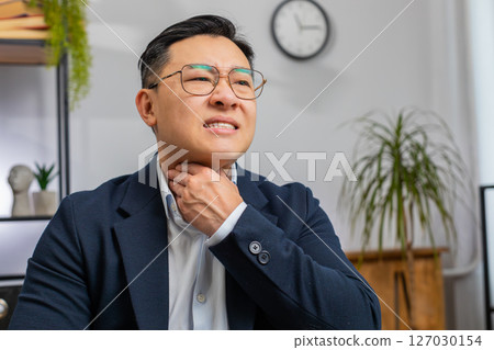 Asian office business man feeling unwell sick ill suffering from sore throat hurt swallowing pain 127030154