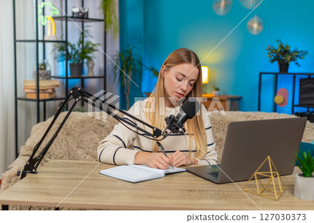Caucasian young adult woman working on blog planning online stream at home sofa table, inspiring 127030373