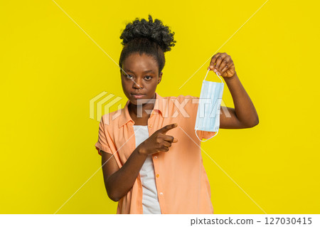 African American woman holding medical mask, gesturing explanation, focused expression, health topic African American woman holding medical mask, gesturing explanation, focused expression, health topic 127030415