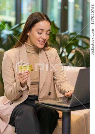 Business woman using credit bank card and laptop, transferring money, purchases online shopping 127030788