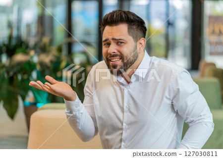 Angry businessman raising hands in indignant expression, asking reason of failure in office lobby Angry businessman raising hands in indignant expression, asking reason of failure in office lobby 127030811
