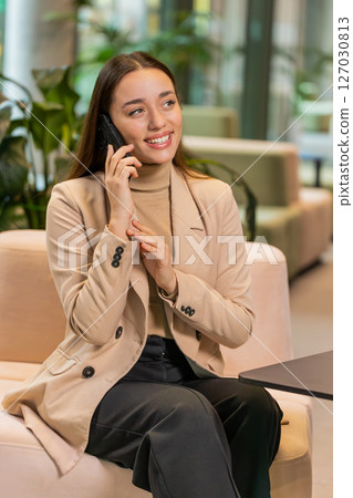 Happy surprised business woman in pleasant conversation phone call good news enjoying talking gossip 127030813