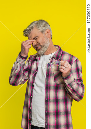 Mature man removing glasses, tired eyes discomfort, post-work fatigue sign, subtle strain expression Mature man removing glasses, tired eyes discomfort, post-work fatigue sign, subtle strain expression 127030830