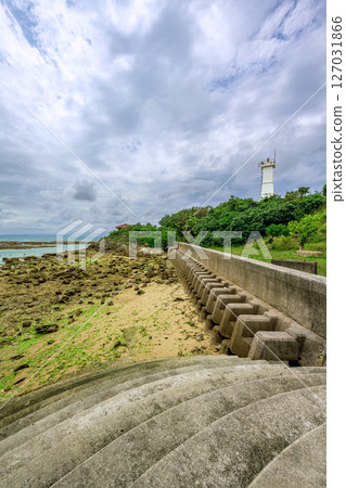 Ryukyu Kannonzaki Lighthouse and the quiet coastline under the rainy season sky. The rocky coast of Ishigaki Island at low tide 127031866