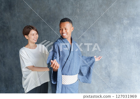 Staff helping foreign tourists put on yukata 127031969