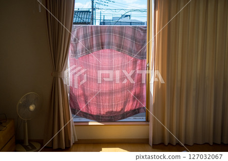 A family drying towels on the balcony 127032067