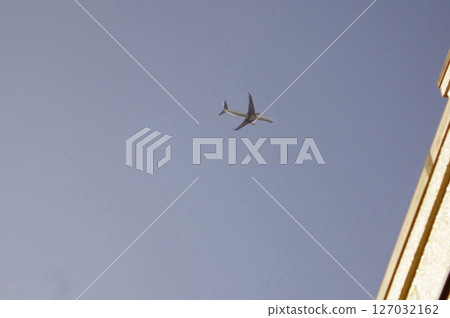 Airplane flying over buildings 127032162