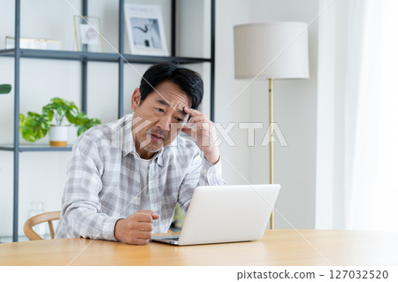 Middle-aged man having trouble with a computer Middle-aged man having trouble with a computer 127032520