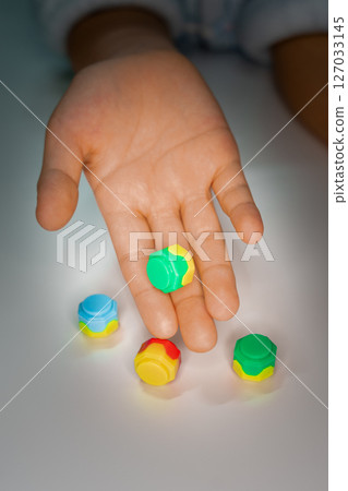 Korean traditional game kit Gonggi. Colourful plastic stones on the hand. Korean traditional game kit Gonggi. Colourful plastic stones on the hand. 127033145
