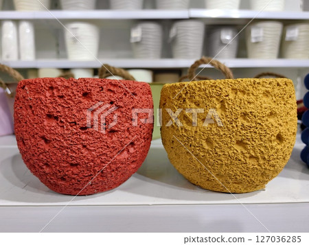colorful textured pots in vibrant red and yellow displayed on shelf in home decor store. closeup. 127036285
