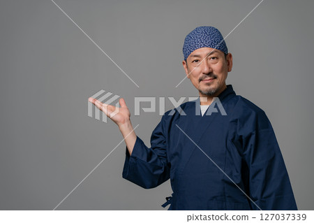A man wearing a work uniform waving his hands 127037339