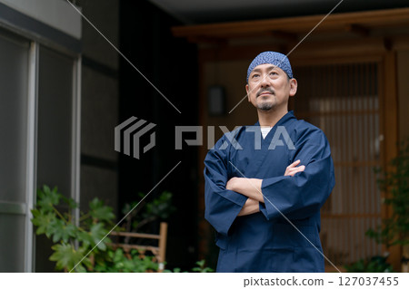 一名身穿工作服、雙臂交叉的男子 127037455