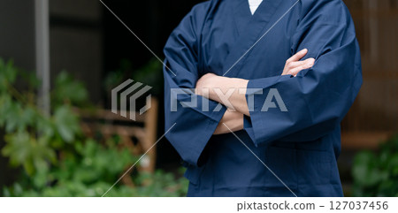 一名身穿工作服、雙臂交叉的男子 127037456