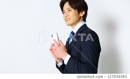 一位男性上班族面帶微笑操作智慧型手機的圖片 127038363