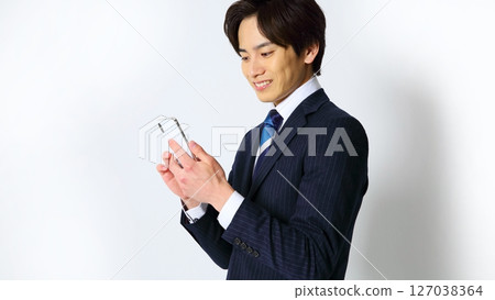 一位男性上班族面帶微笑操作智慧型手機的圖片 127038364