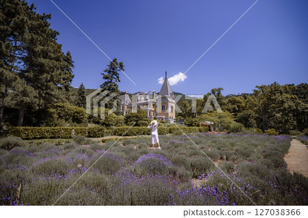 A woman is standing in a field of lavender A woman is standing in a field of lavender 127038366